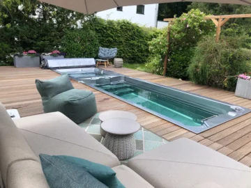 Infinitas SP2250 Swim Spa eingelassen in eine Holzterrasse im Garten mit Lounge