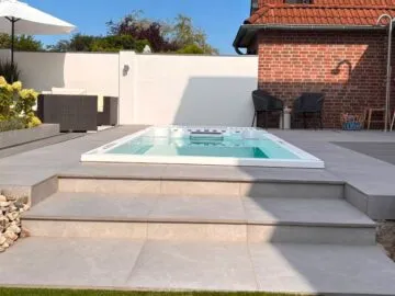 Infinitas SP6000 Swim Spa eingelassen in Terrasse mit Stufen vor Klinkerhaus