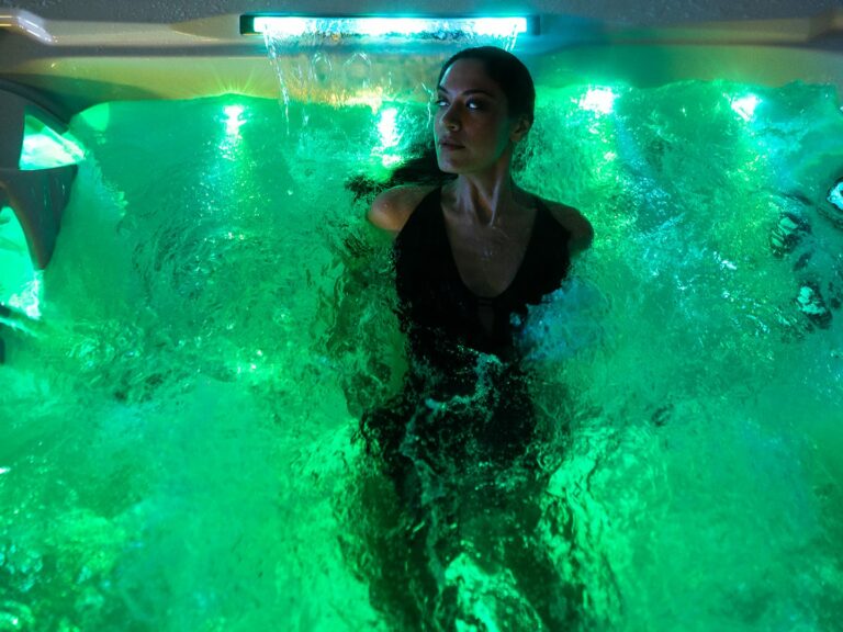 Kundin beim Probebaden in einem beleuchteten Whirlpool in der Ausstellung in Hilden