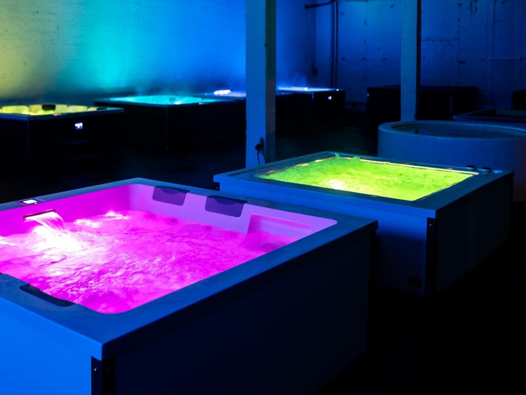Beleuchtete, gefüllte Whirlpools im Testbereich der Spa-Natural-Ausstellung in Hilden