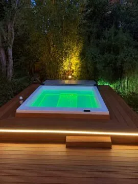 Paolo Ferralli Magnifico Outdoor Whirlpool auf Holzterrasse bei Nacht mit grüner LED