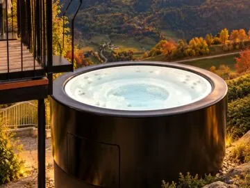 Infinitas The Circle Outdoor-Whirlpool bei Sonnenuntergang vor Alpenpanorama